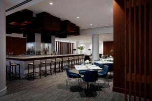 un restaurante con mesas y sillas y un bar en Long Island Marriott Hotel en Uniondale