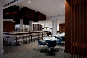 um restaurante com mesas e cadeiras e um bar em Long Island Marriott Hotel em Uniondale