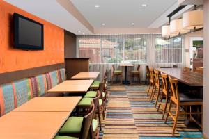 a restaurant with tables and chairs and a tv on the wall at Fairfield Inn & Suites by Marriott Albuquerque Airport in Albuquerque