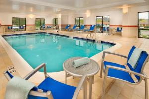 una piscina con sillas y una mesa en una habitación de hotel en TownePlace Suites Bridgeport Clarksburg, en Bridgeport