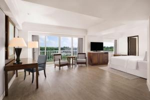 a hotel room with a bed and a desk and a television at The Westin Resort Guam in Tumon