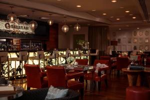un restaurant avec des tables et des chaises ainsi qu'un bar dans l'établissement Renaissance Baton Rouge Hotel, à Bâton-Rouge