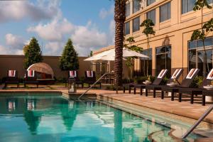 ein Hotelpool mit Stühlen und ein Gebäude in der Unterkunft Renaissance Baton Rouge Hotel in Baton Rouge