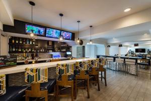 un restaurante con un bar con mesas y sillas en Four Points by Sheraton Charlotte - Lake Norman, en Huntersville