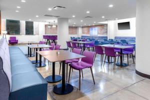 TownePlace Suites by Marriott Dallas Downtown في دالاس: غرفة طعام مع طاولات وكراسي أرجوانية
