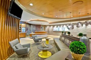 a lobby with a couch and chairs and a bar at SpringHill Suites Cincinnati Airport South in Florence