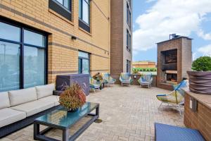 a patio with a couch and chairs and a fireplace at SpringHill Suites Cincinnati Airport South in Florence