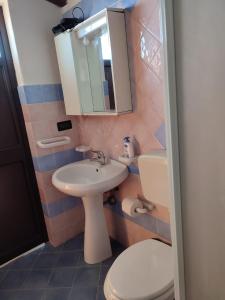 a bathroom with a sink and a toilet and a mirror at Villa in vetro in Castellammare del Golfo