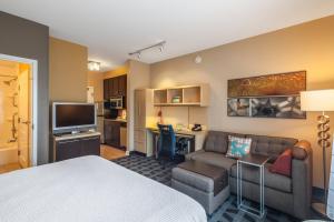 ジャクソンビルにあるTownePlace Suites Jacksonville Butler Boulevardのベッドとリビングルームが備わるホテルルームです。
