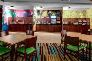 a restaurant with tables and chairs and a bar at Fairfield Inn & Suites by Marriott Lansing at Eastwood in Lansing
