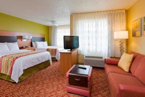 a hotel room with two beds and a flat screen tv at TownePlace Suites by Marriott Dallas Bedford in Bedford