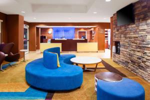a lobby with blue chairs and a table at Fairfield Inn & Suites Macon in Macon