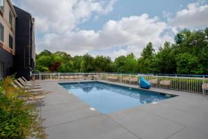 a swimming pool with chairs and a fence at Fairfield Inn & Suites Macon in Macon