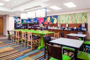 a restaurant with green tables and chairs and a cafeteria at Fairfield Inn & Suites Macon in Macon