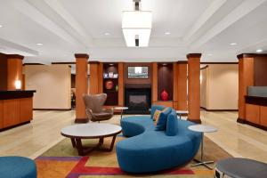 vestíbulo con sofá azul, mesa y sillas en Fairfield Inn and Suites by Marriott Saint Augustine I-95, en St. Augustine