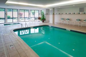 a pool in a hotel with chairs and tables at Courtyard Bristol in Bristol