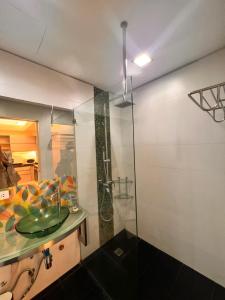 een badkamer met een glazen douche en een wastafel bij The Pearl Interior Designed 1 BR Unit Burgos Circle BGC in Manilla