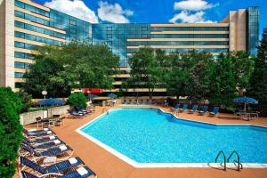 a swimming pool with lounge chairs and a building at Sheraton Imperial Hotel Raleigh-Durham Airport at Research Triangle Park in Durham
