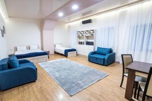 a living room with two blue chairs and a table at Tiflis Hotel in Tbilisi City