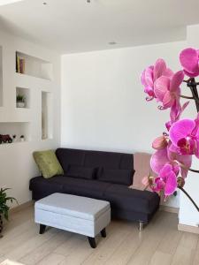 sala de estar con sofá azul y orquídeas púrpuras en Diego's Apartment - Monza Park, en Biassono