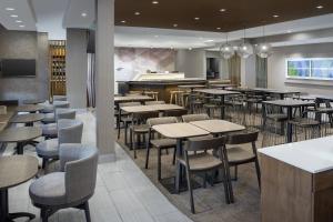 a restaurant with tables and chairs and a bar at SpringHill Suites by Marriott Loveland Fort Collins/Windsor in Windsor