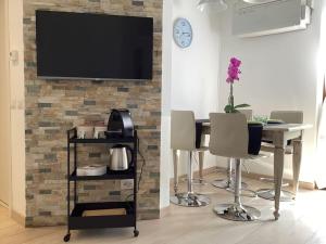 a dining room with a table and a tv on a brick wall at Diego's Apartment - Monza Park in Biassono