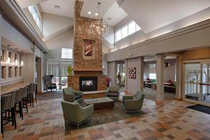 a lobby with a stone fireplace and chairs at Residence Inn by Marriott Atlantic City Airport Egg Harbor Township in Egg Harbor Township