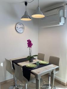 mesa de comedor con sillas y reloj en la pared en Diego's Apartment - Monza Park, en Biassono