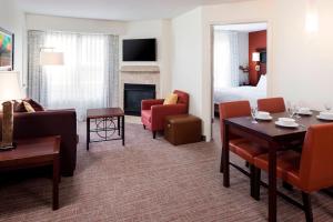 Habitación de hotel con sala de estar con comedor. en Residence Inn by Marriott Billings, en Billings
