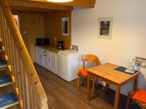 a small kitchen with a table and a refrigerator at Hotel Schachten in Lindberg