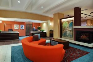 Residence Inn by Marriott Little Rock Downtown في ليتل روك: لوبي فيه كرسي برتقالي وموقد