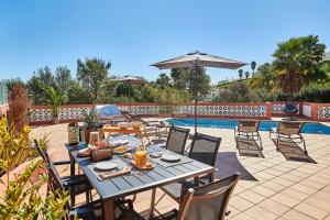 un patio con tavolo e sedie accanto alla piscina di Panorama Castro Marim - Deluxe Villa With Pool a Castro Marim