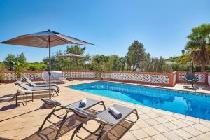 una piscina con sedie a sdraio e ombrellone di Panorama Castro Marim - Deluxe Villa With Pool a Castro Marim