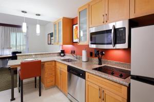 a kitchen with wooden cabinets and a counter top at Residence Inn by Marriott Little Rock Downtown in Little Rock