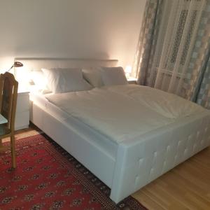 ein großes weißes Bett in einem Zimmer mit einem roten Teppich in der Unterkunft Weißes Appartement in Wien