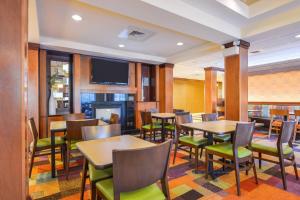 Fairfield Inn & Suites White Marsh في بالتيمور: مطعم بطاولات وكراسي وتلفزيون بشاشة مسطحة