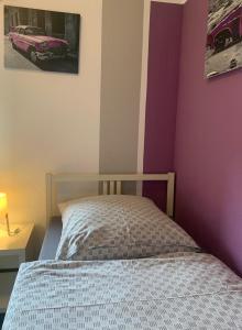 a bedroom with a bed and a purple wall at Hotel Zur Schleuse (Garni) in Datteln