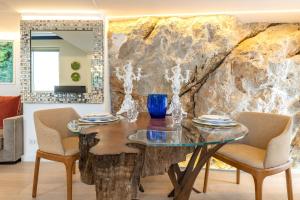 comedor con mesa de cristal y sillas en Casa Boutique by Capri 5 Senses, en Capri