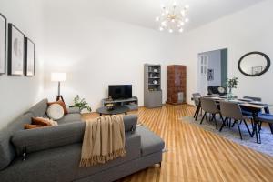 een woonkamer met een bank en een eetkamer bij WAWELOVE Piłsudskiego - 3 bedroom apt. with balcony and free parking! in Krakau