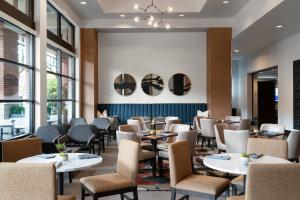 a restaurant with tables and chairs and windows at Seattle Marriott Redmond in Redmond