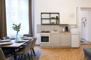 een keuken en eetkamer met een tafel en stoelen bij WAWELOVE Piłsudskiego - 3 bedroom apt. with balcony and free parking! in Krakau