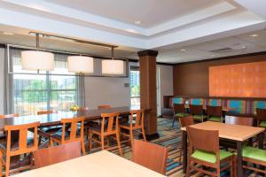 a dining room with tables and chairs and windows at Fairfield Inn & Suites by Marriott Omaha Downtown in Omaha