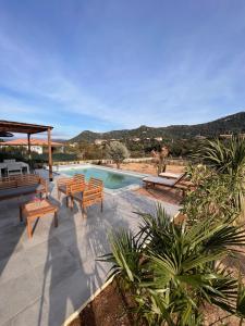 a swimming pool with wooden benches and a swimming pool at Casa Agatha : Villa avec piscine in Figari