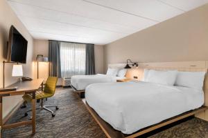 ein Hotelzimmer mit 2 Betten und einem Schreibtisch in der Unterkunft Fairfield Inn & Suites by Marriott Providence Airport Warwick in Warwick