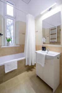 a bathroom with a tub and a sink and a mirror at WAWELOVE Piłsudskiego - 3 bedroom apt. with balcony and free parking! in Kraków