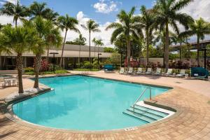 una piscina con palmeras y un edificio en Miami Airport Marriott, en Miami