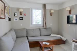 a living room with a couch and a window at Appartement Les Grands Pins, entre Lac et Océan in Carcans