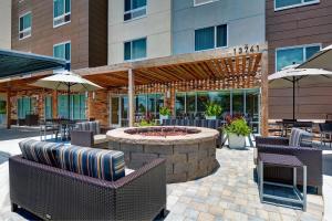 een patio met stoelen en een vuurplaats voor een gebouw bij TownePlace Suites by Marriott Jacksonville East in Jacksonville