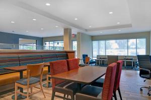 a dining room with tables and chairs and windows at TownePlace Suites by Marriott Jacksonville East in Jacksonville