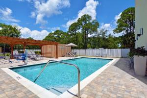 una piscina con un riel de metal en un patio en TownePlace Suites by Marriott Jacksonville East, en Jacksonville